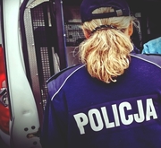 zdjęcie policjantki z tyłu stojącej przy radiowozie
